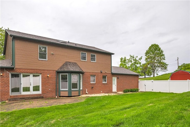 back of house featuring brick siding and roof with shingles