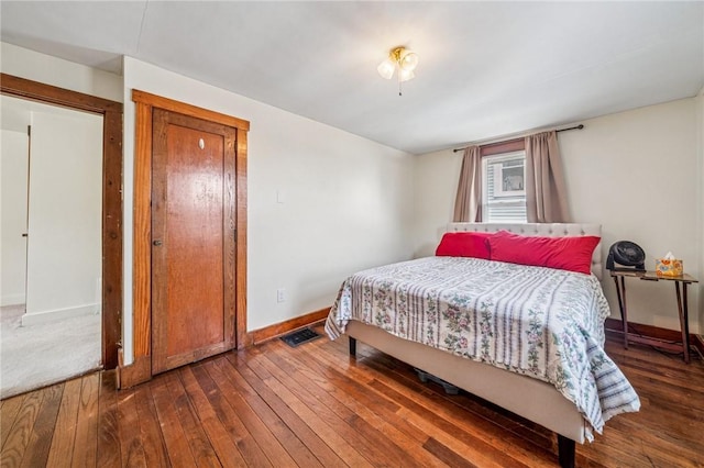 bedroom with baseboards and hardwood / wood-style flooring