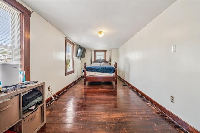 bedroom featuring dark wood-style flooring and baseboards