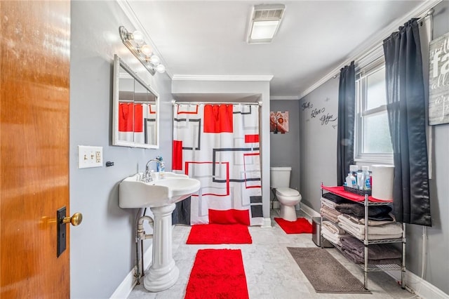 bathroom with ornamental molding, baseboards, and toilet