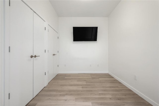 unfurnished bedroom with baseboards and light wood-style floors