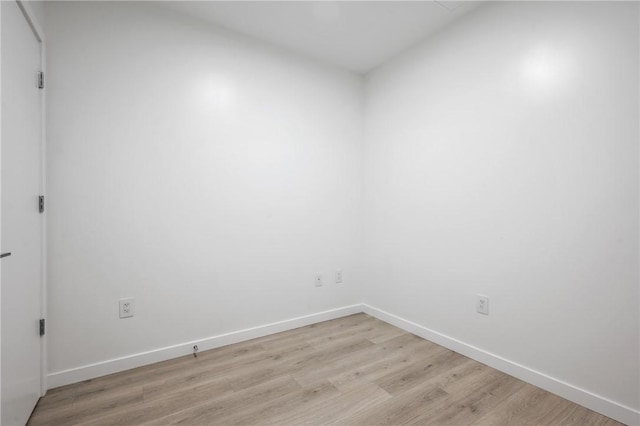 unfurnished room with light wood-style flooring and baseboards