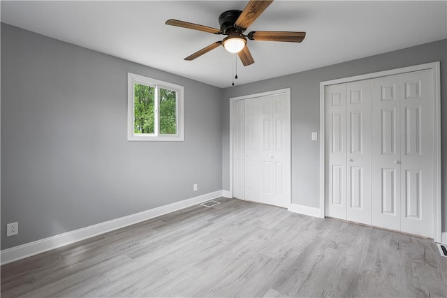 1111 Logan Rd, Bethel Park, PA 15102 - unfurnished bedroom featuring multiple closets, wood finished floors, baseboards, and ceiling fan