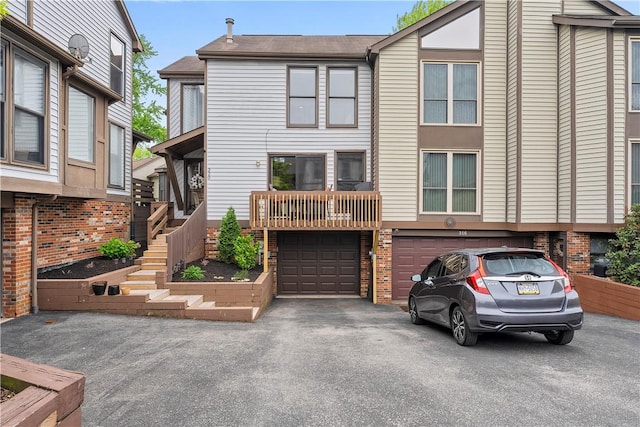 view of front facade featuring a garage, driveway, and stairs