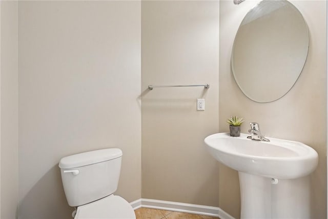 bathroom featuring toilet, tile patterned floors, and baseboards