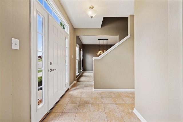 entrance foyer with plenty of natural light, light tile patterned flooring, and baseboards