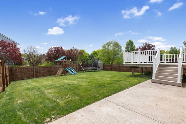 view of yard with a patio, a deck, a storage unit, a playground, and stairs