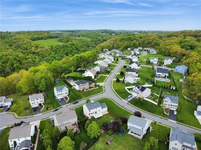 view of property location featuring a heavily wooded area and nearby suburban area