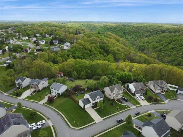aerial overview of property's location featuring a forest and nearby suburban area