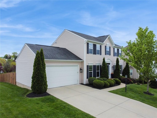 colonial-style house with a garage, driveway, and a shingled roof