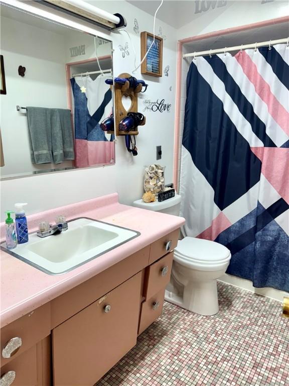 full bathroom featuring vanity, toilet, and curtained shower
