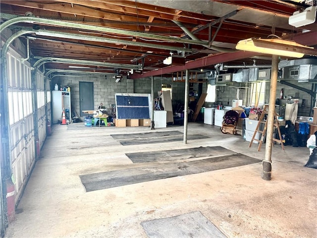 below grade area with washer and clothes dryer and concrete block wall