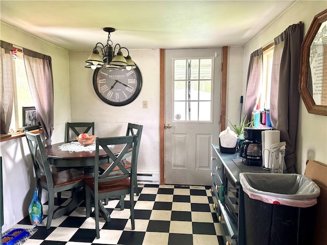 dining space featuring light floors, a chandelier, and a baseboard heating unit