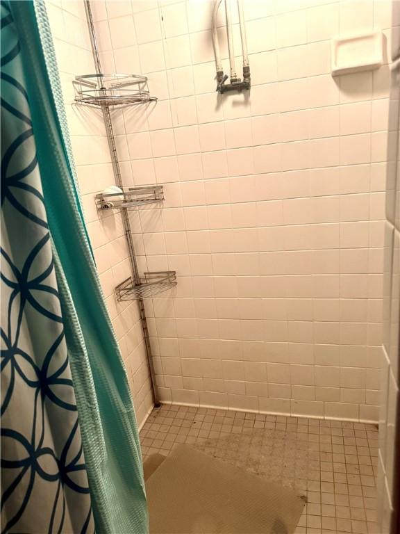 full bath with a tile shower