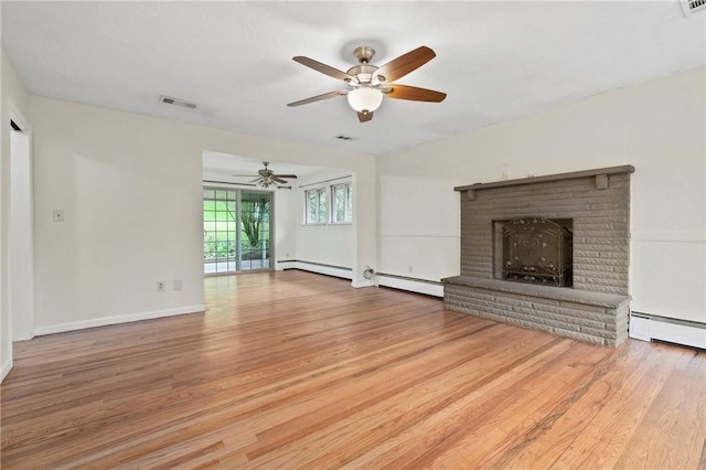 unfurnished living room featuring baseboard heating, ceiling fan, wood finished floors, and a fireplace
