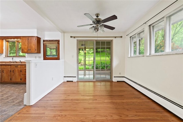 entryway featuring baseboard heating, a baseboard heating unit, light wood-type flooring, a ceiling fan, and a sink