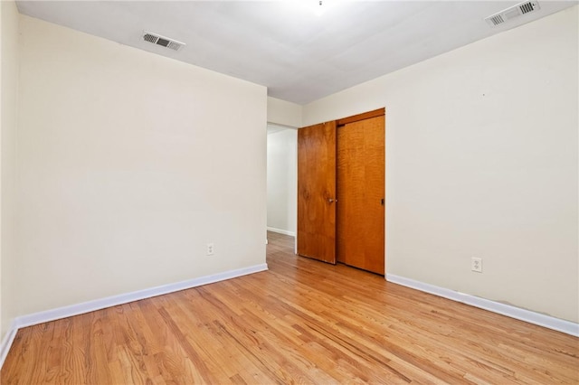 empty room featuring baseboards and light wood-style flooring