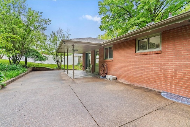 view of home's exterior with a patio area, fence, and brick siding