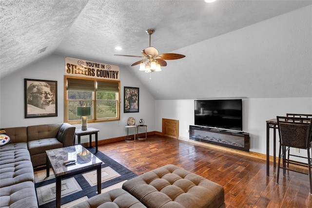 living area featuring a textured ceiling, wood-type flooring, baseboards, lofted ceiling, and ceiling fan