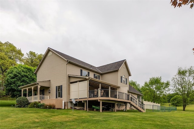 back of property featuring a lawn, a wooden deck, stairway, and a ceiling fan