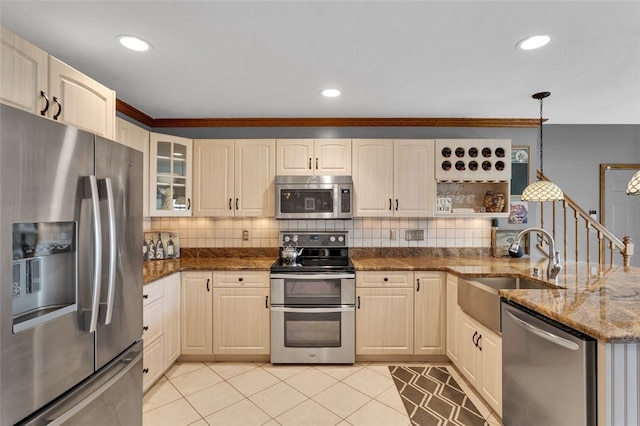 kitchen featuring appliances with stainless steel finishes, a sink, backsplash, decorative light fixtures, and glass insert cabinets