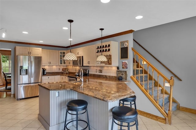 kitchen with stainless steel appliances, a peninsula, a kitchen breakfast bar, tasteful backsplash, and glass insert cabinets