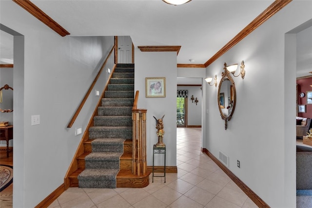 stairway with tile patterned flooring, baseboards, and crown molding