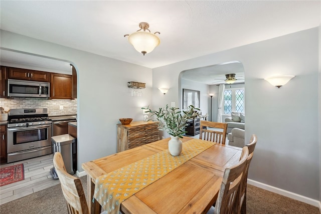112 Cranbrooke Dr, Findlay Twp, PA 15108 - dining space with arched walkways, ceiling fan, light colored carpet, and baseboards