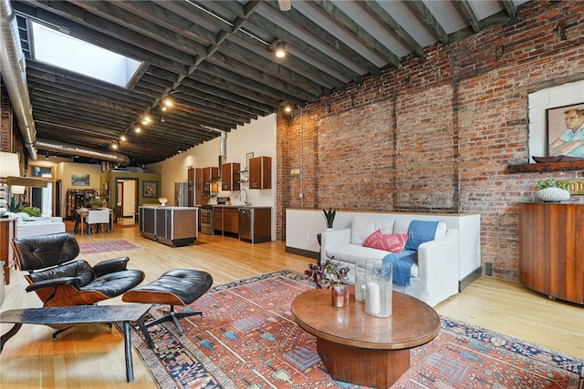 living room with brick wall and light wood-style floors