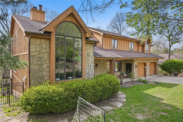 4616 Windbrook, Murrysville, PA 15668 - view of front facade with stone siding, a chimney, board and batten siding, concrete driveway, and roof with shingles