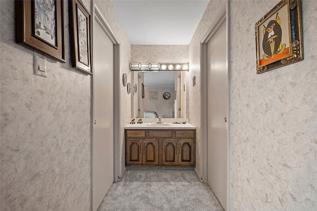 hallway with light carpet and a sink