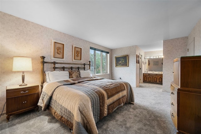 carpeted bedroom featuring ensuite bathroom and wallpapered walls
