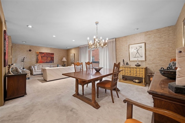 dining room with light colored carpet, a chandelier, and wallpapered walls
