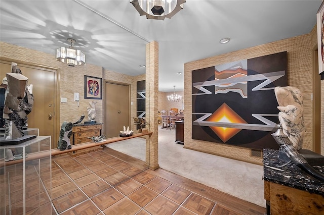 foyer with a chandelier and wallpapered walls