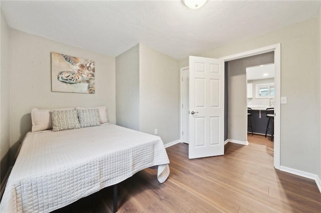 bedroom featuring wood finished floors and baseboards