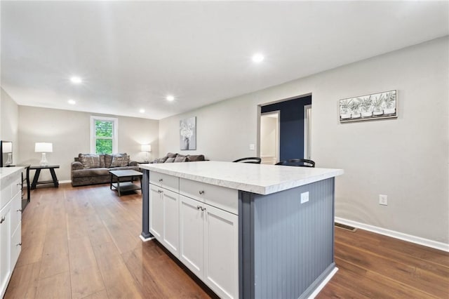 kitchen with white cabinetry, light countertops, dark wood finished floors, and recessed lighting