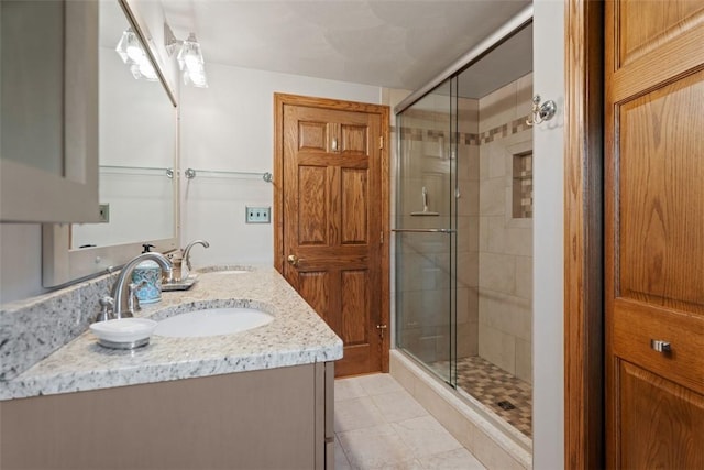 bathroom with a stall shower, double vanity, and tile patterned floors
