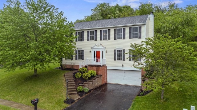 939 White Water Dr, Adams Twp, PA 16046 - colonial house featuring asphalt driveway, an attached garage, a front lawn, and a chimney