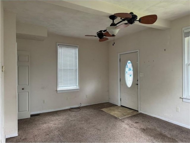 carpeted entryway with ceiling fan, plenty of natural light, and baseboards