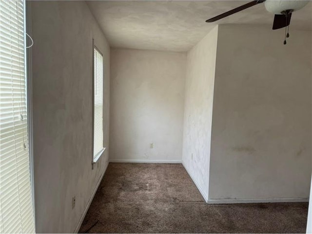 unfurnished room featuring carpet floors, a ceiling fan, and baseboards