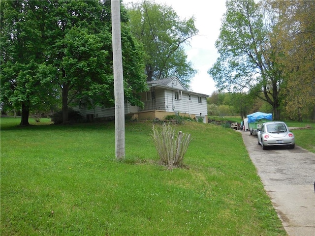 view of side of home with a lawn and asphalt driveway