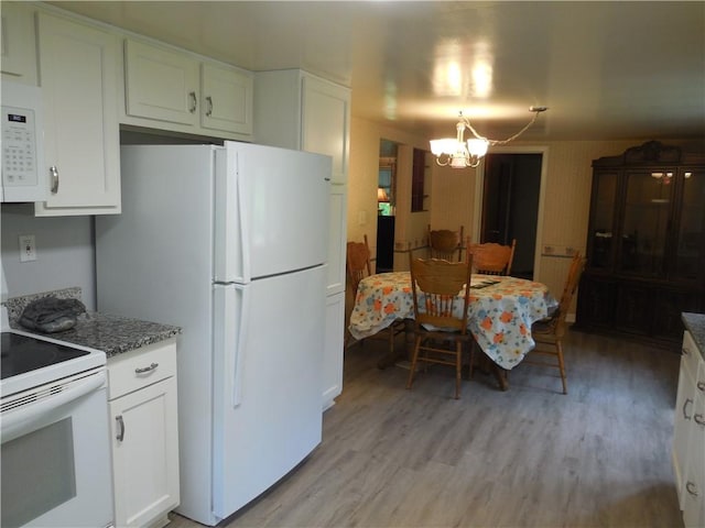 kitchen featuring white appliances, a chandelier, light wood finished floors, white cabinetry, and stone countertops