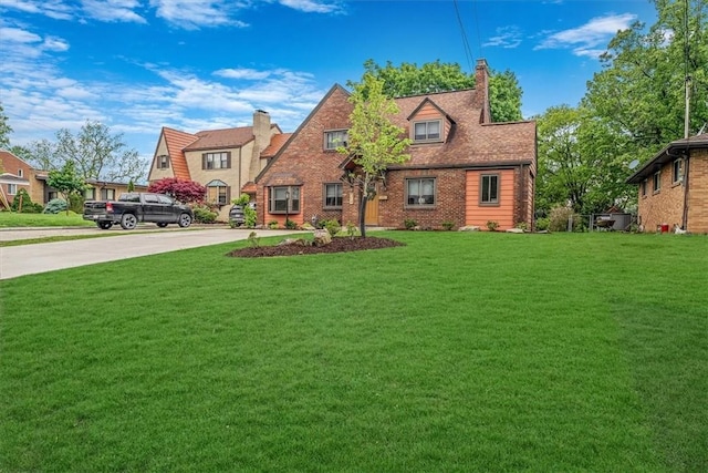 view of front of house featuring a chimney, a front yard, and driveway