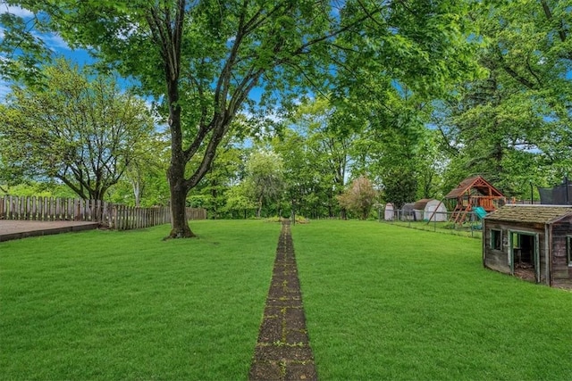 view of yard with a playground and view of wooded area