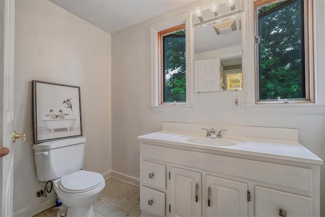 bathroom with baseboards, healthy amount of natural light, and vanity