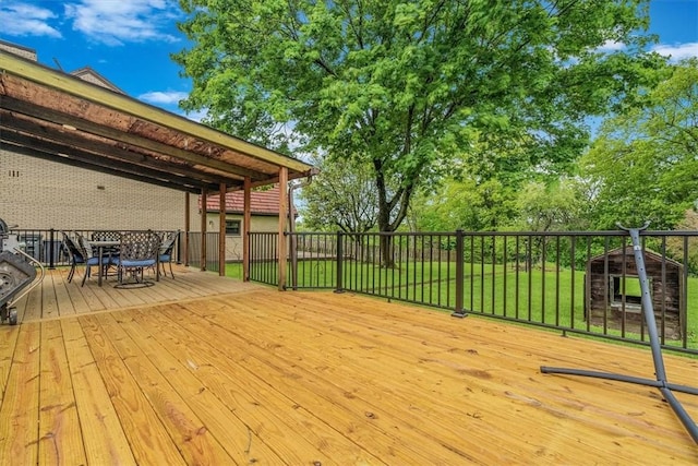 wooden deck featuring outdoor dining area and a yard