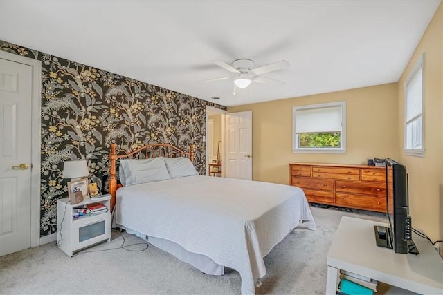 carpeted bedroom featuring wallpapered walls and a ceiling fan