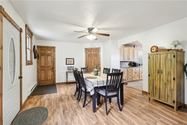 1770 Perry Hwy, Muddy Creek Twp, PA 16051 - dining room with a baseboard radiator, light wood-style floors, a ceiling fan, arched walkways, and baseboards