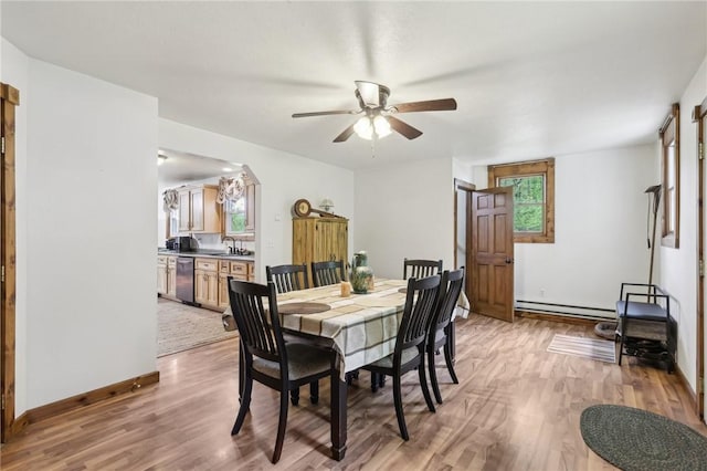 1770 Perry Hwy, Muddy Creek Twp, PA 16051 - dining area featuring a baseboard radiator, light wood-style floors, a ceiling fan, and baseboards