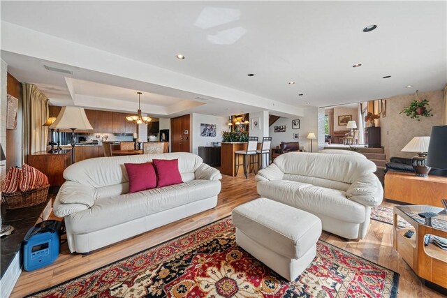257 Penhurst Dr, Wilkins Twp, PA 15235 - living area featuring a chandelier, a tray ceiling, and light wood-style floors